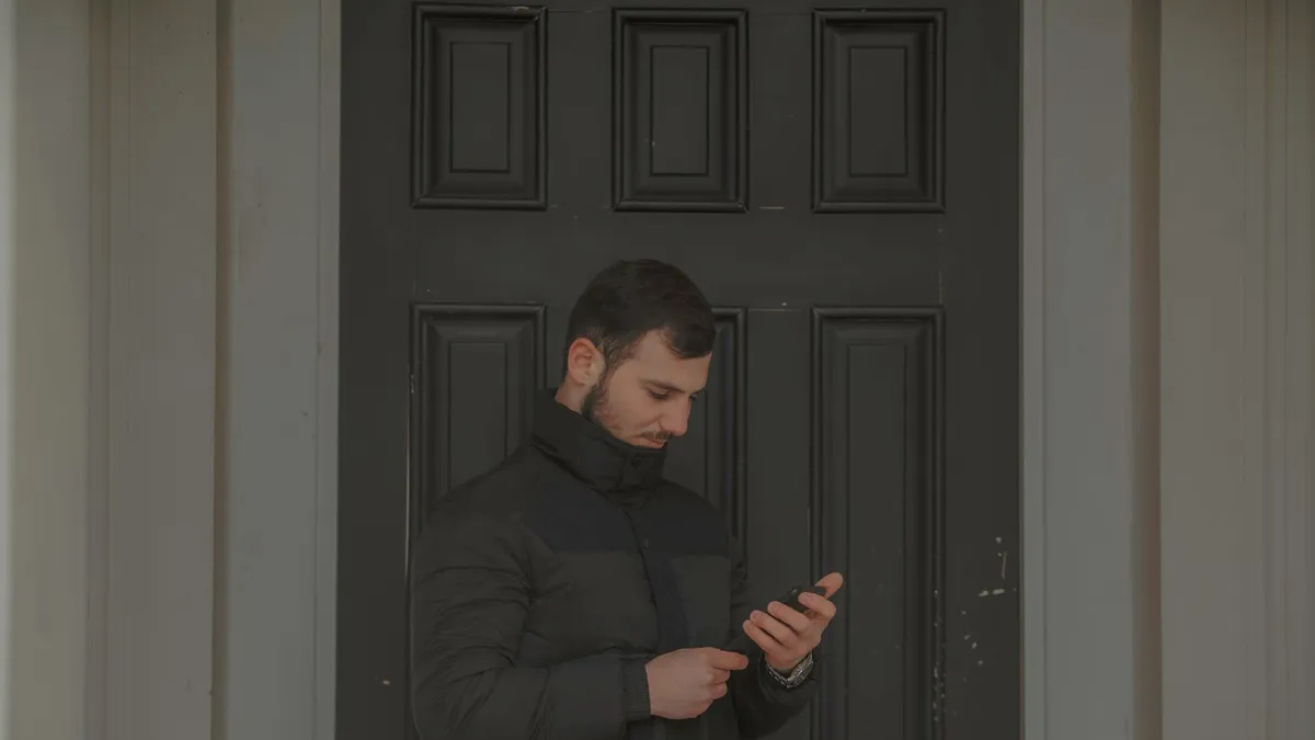 A person in a winter coat checking a loan offer on a phone in Winnipeg, reading the fee and due date before signing