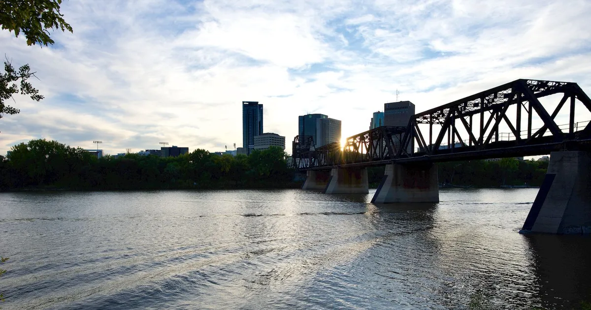 The Winnipeg downtown skyline beside the Assiniboine rail bridge, the city where loans Winnipeg borrowers take out online follow Manitoba rules